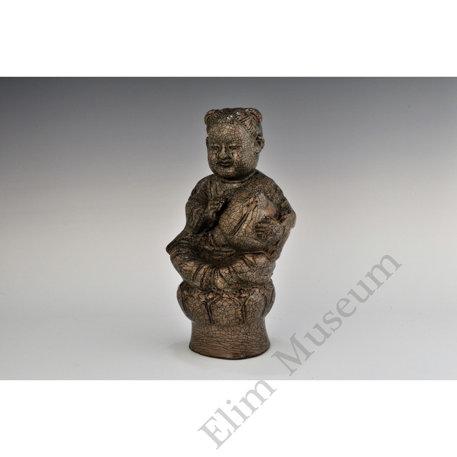 1724 Yue ware figure of a boy holding a peach