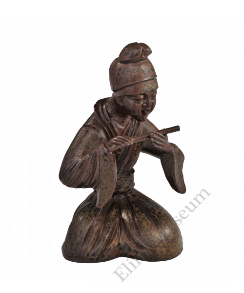 1725 A Yue ware figure of a young flute player with green decoration