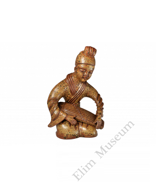 1742 A Yue ware figure of a young zither player with green decoration