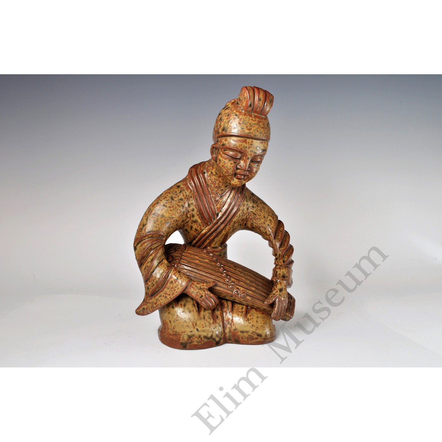 1742 A Yue ware figure of a young pipa player with green decoration