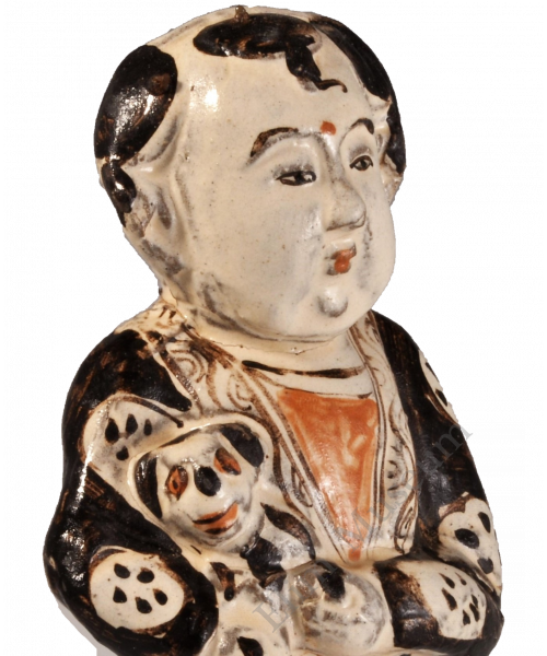 1744 A Cizhou ware figure of a boy holding a dog, decorated in red and black